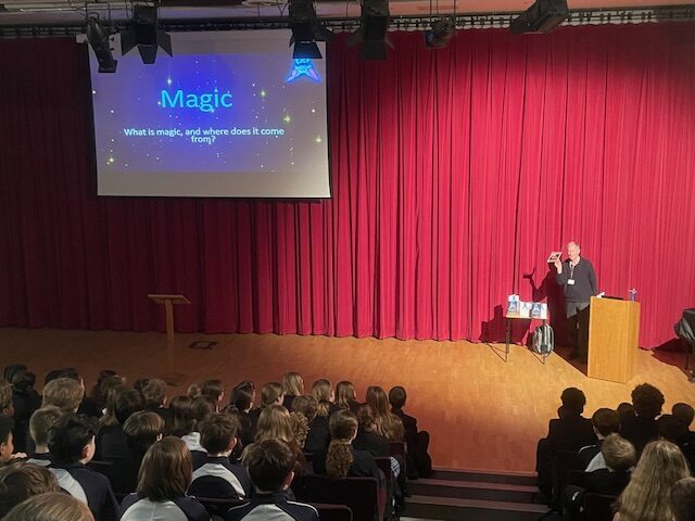 Red curtain before stage, Vincent Shaw reading and extract from Bert the Bat to 220 children at Rother College, Midhurst Sussex.